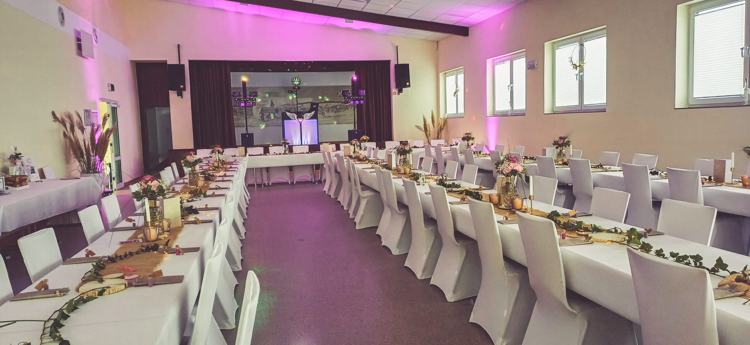 Stuhlhussen Bürgersaal Laufdorf Schöffengrund Weiße Stuhlhussen im Bürgersaal Laufdorf in Schöffengrund bei einer Feier – elegante Dekoration für Hochzeiten und besondere Veranstaltungen
