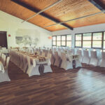 Weiße Stuhlhussen im Dorfgemeinschaftshaus Bergheim in Ortenberg bei einer Feier – elegante Dekoration für Hochzeiten und besondere Veranstaltungen