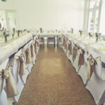 Weiße Stuhlhussen im Dorfgemeinschaftshaus Roßbach in Bischoffen bei einer Feier – elegante Dekoration für Hochzeiten und besondere Veranstaltungen