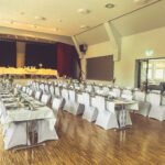 Weiße Stuhlhussen im Dorfgemeinschaftshaus in Rückweiler bei einer Feier – elegante Dekoration für Hochzeiten und besondere Veranstaltungen