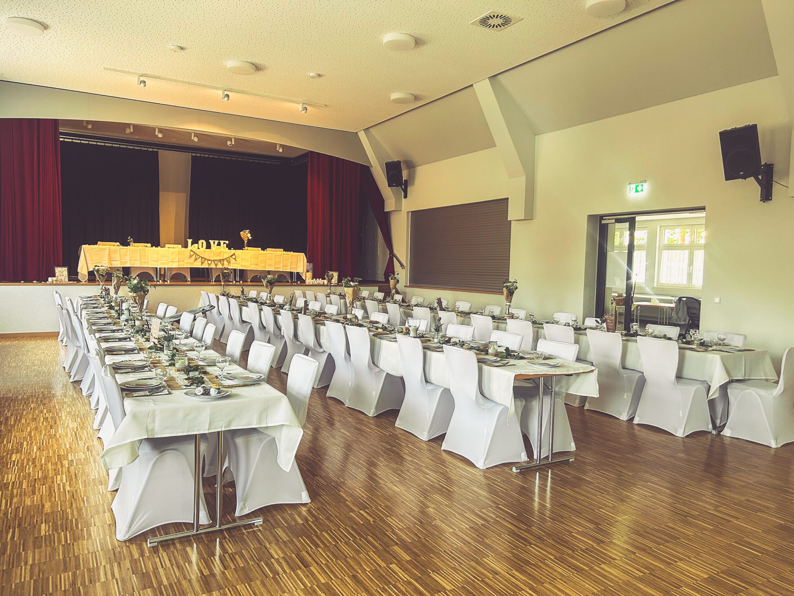 Stuhlhussen Dorfgemeinschaftshaus Rückweiler Weiße Stuhlhussen im Dorfgemeinschaftshaus in Rückweiler bei einer Feier – elegante Dekoration für Hochzeiten und besondere Veranstaltungen