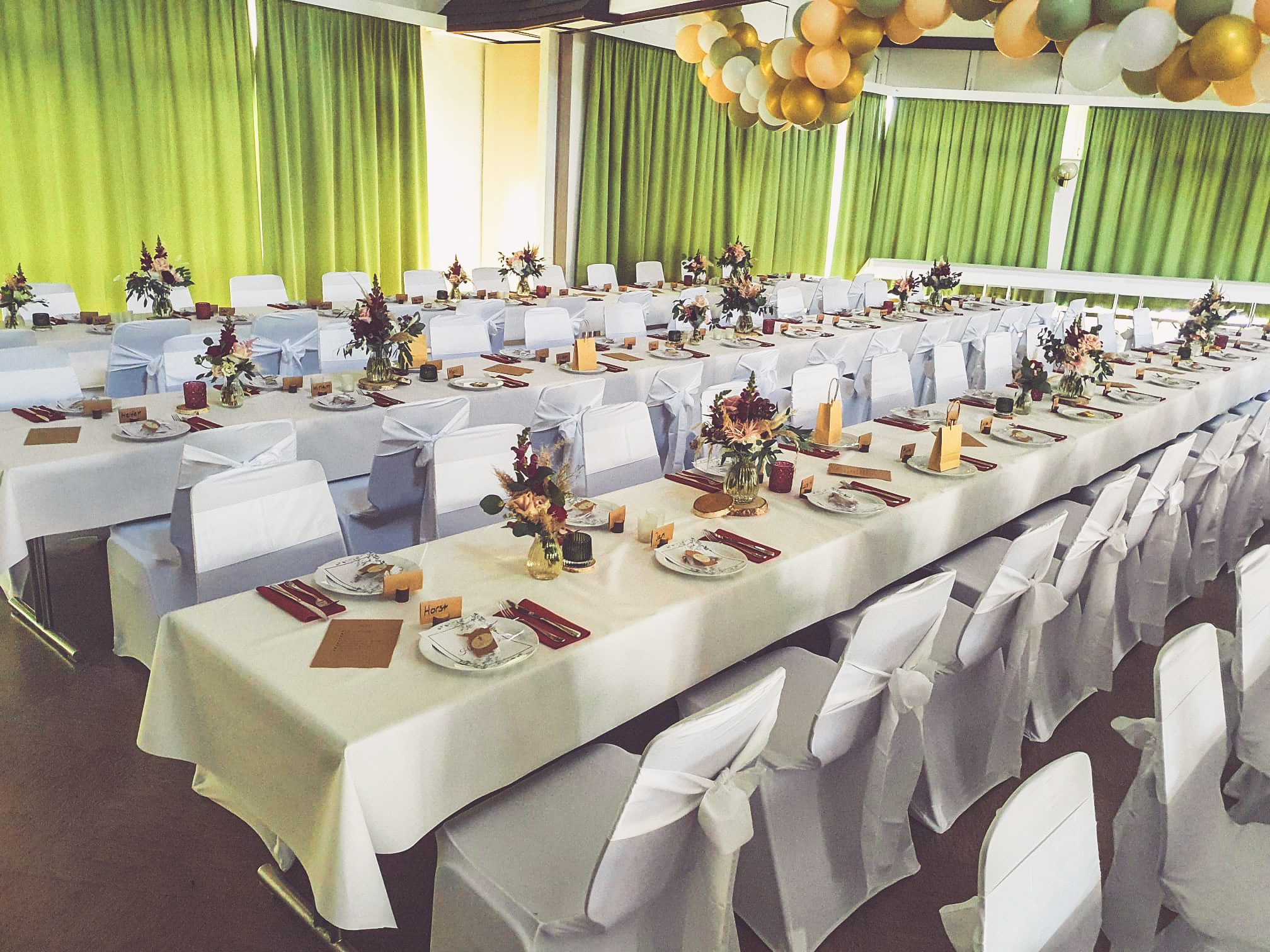 Weiße Stuhlhussen im Dorfgemeinschaftshaus Wolf in Büdingen bei einer Feier – elegante Dekoration für Hochzeiten und besondere Veranstaltungen