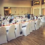 Weiße Stuhlhussen in der Gemeindehalle in Cölbe bei einer Feier – elegante Dekoration für Hochzeiten und besondere Veranstaltungen