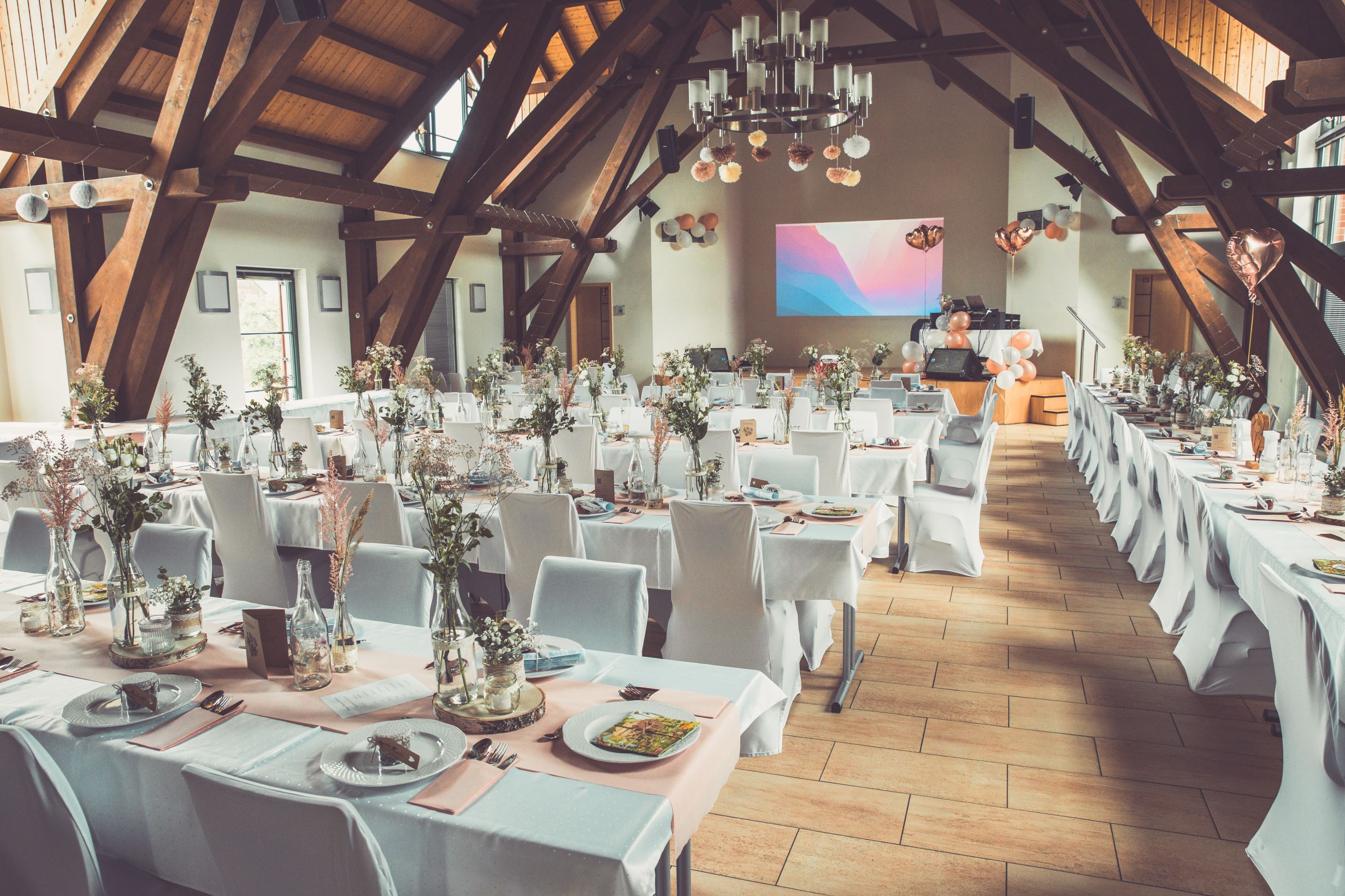Weiße Stuhlhussen im Gemeindezentrum in Heinsdorfergrund bei einer Feier – elegante Dekoration für Hochzeiten und besondere Veranstaltungen