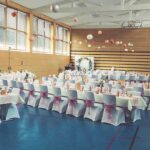 Weiße Stuhlhussen in der Sampo-Halle Bingenheim in Echzell bei einer Feier – elegante Dekoration für Hochzeiten und besondere Veranstaltungen