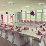 Weiße Stuhlhussen im Dorfgemeinschaftshaus Eitra in Hauneck bei einer Feier – elegante Dekoration für Hochzeiten und besondere Veranstaltungen