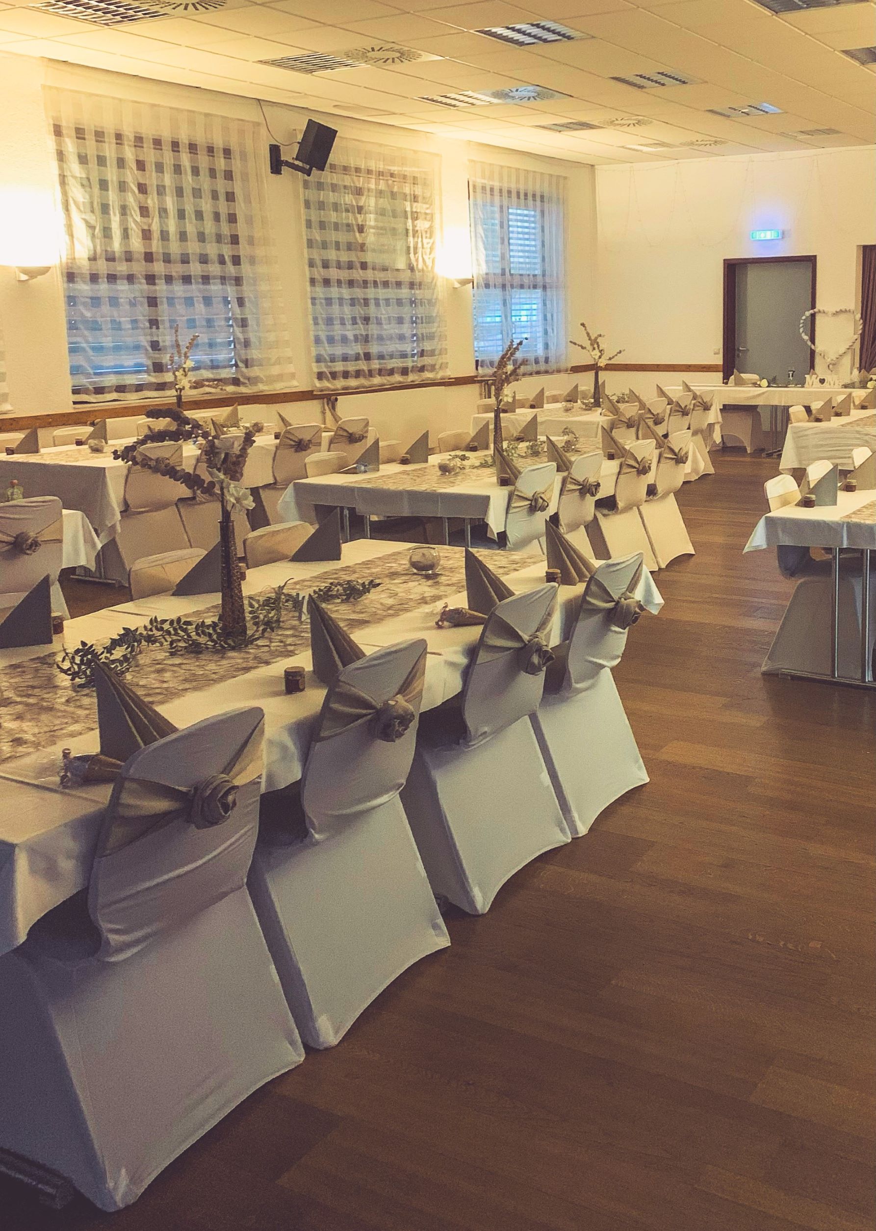 Weiße Stuhlhussen im Dorfgemeinschaftshaus Steinbach in Michelstadt bei einer Feier – elegante Dekoration für Hochzeiten und besondere Veranstaltungen