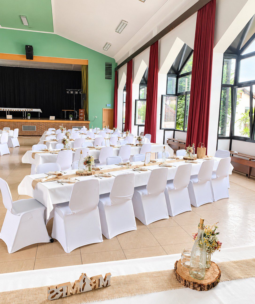 Weiße Stuhlhussen in der Fritz-Henkel-Halle in Wallau bei einer Feier – elegante Dekoration für Hochzeiten und besondere Veranstaltungen
