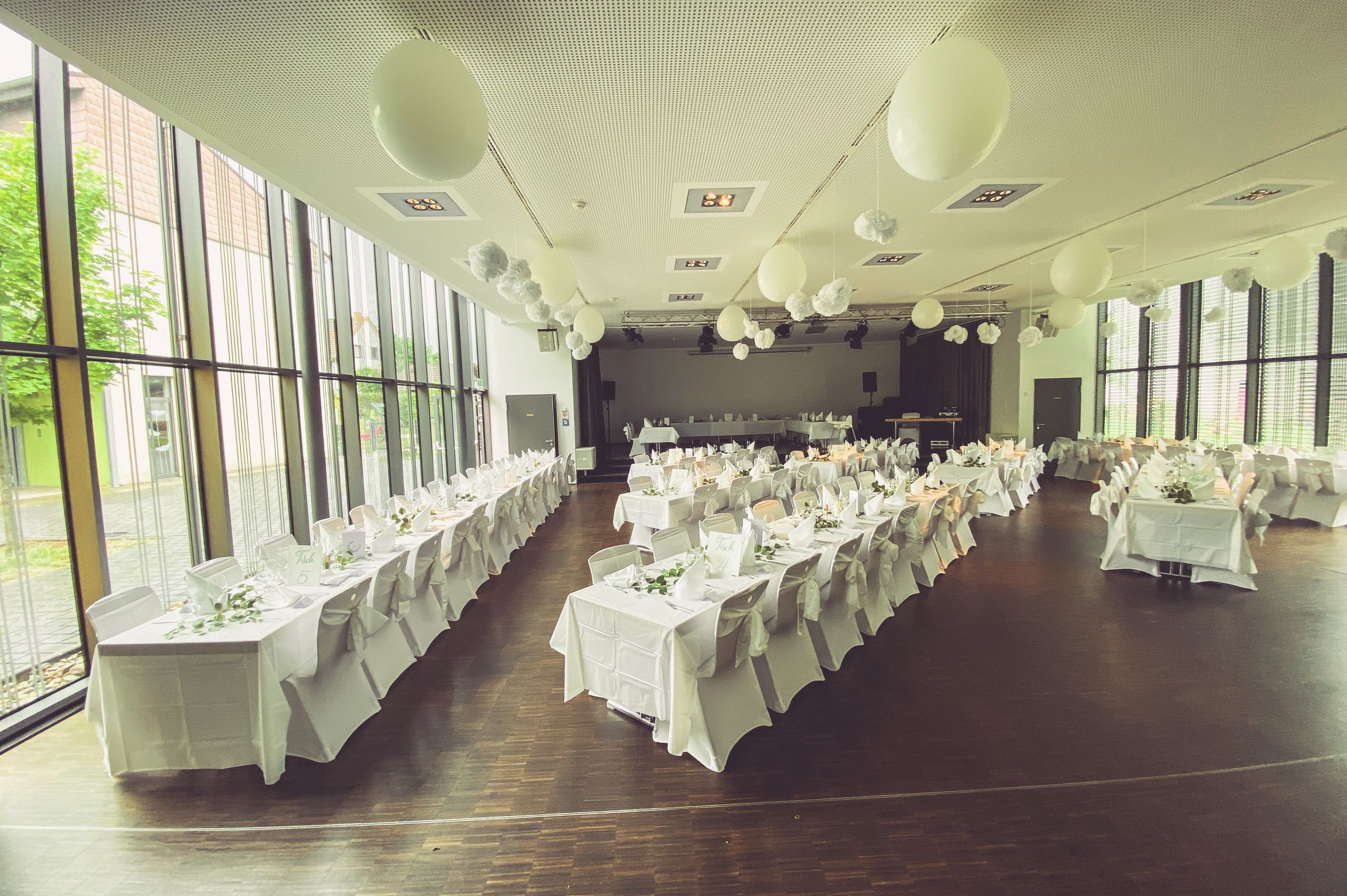 Weiße Stuhlhussen im Gemeindezentrum Bliesen in St. Wendel bei einer Feier – elegante Dekoration für Hochzeiten und besondere Veranstaltungen