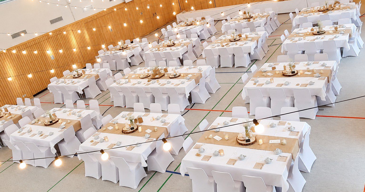 Mehrzweckhalle Ottensoos – Hochzeit mit Stuhlhussen Hochzeit mit 120 Personen in der Mehrzweckhalle Ottensoos mit weißen Stuhlhussen