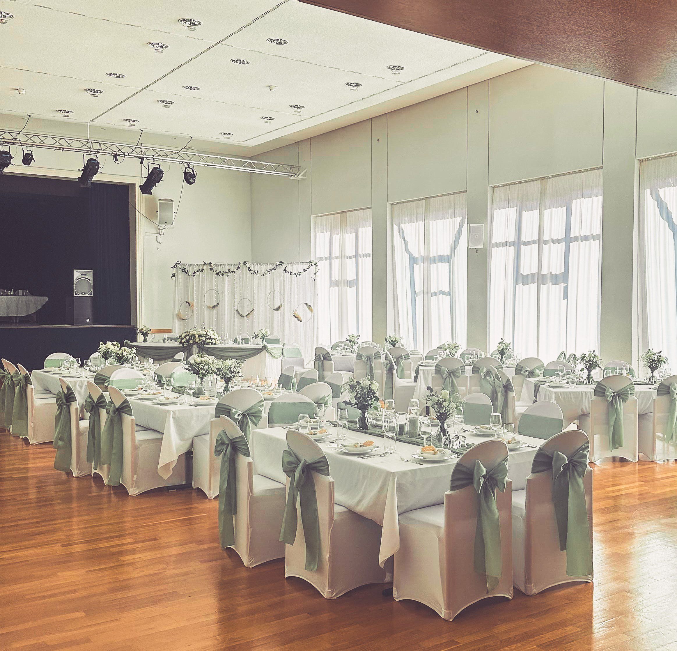 Weiße Stuhlhussen im Kurpfalzsaal in Edenkoben bei einer Feier – elegante Dekoration für Hochzeiten und besondere Veranstaltungen