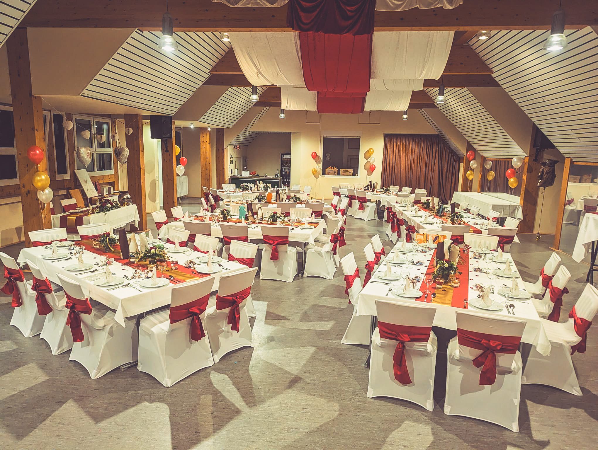 Weiße Stuhlhussen im Haus der Gemeinde in Rüber bei einer Feier – elegante Dekoration für Hochzeiten und besondere Veranstaltungen