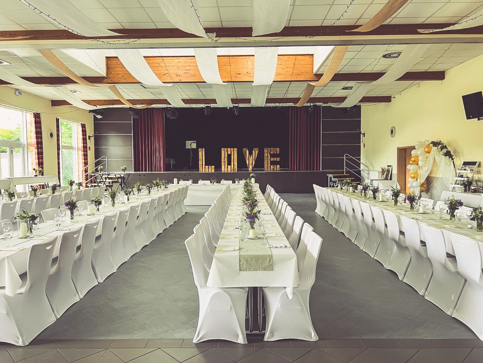 Weiße Stuhlhussen im Bürgertreff Langbroich in Gangelt bei einer Feier – elegante Dekoration für Hochzeiten und besondere Veranstaltungen