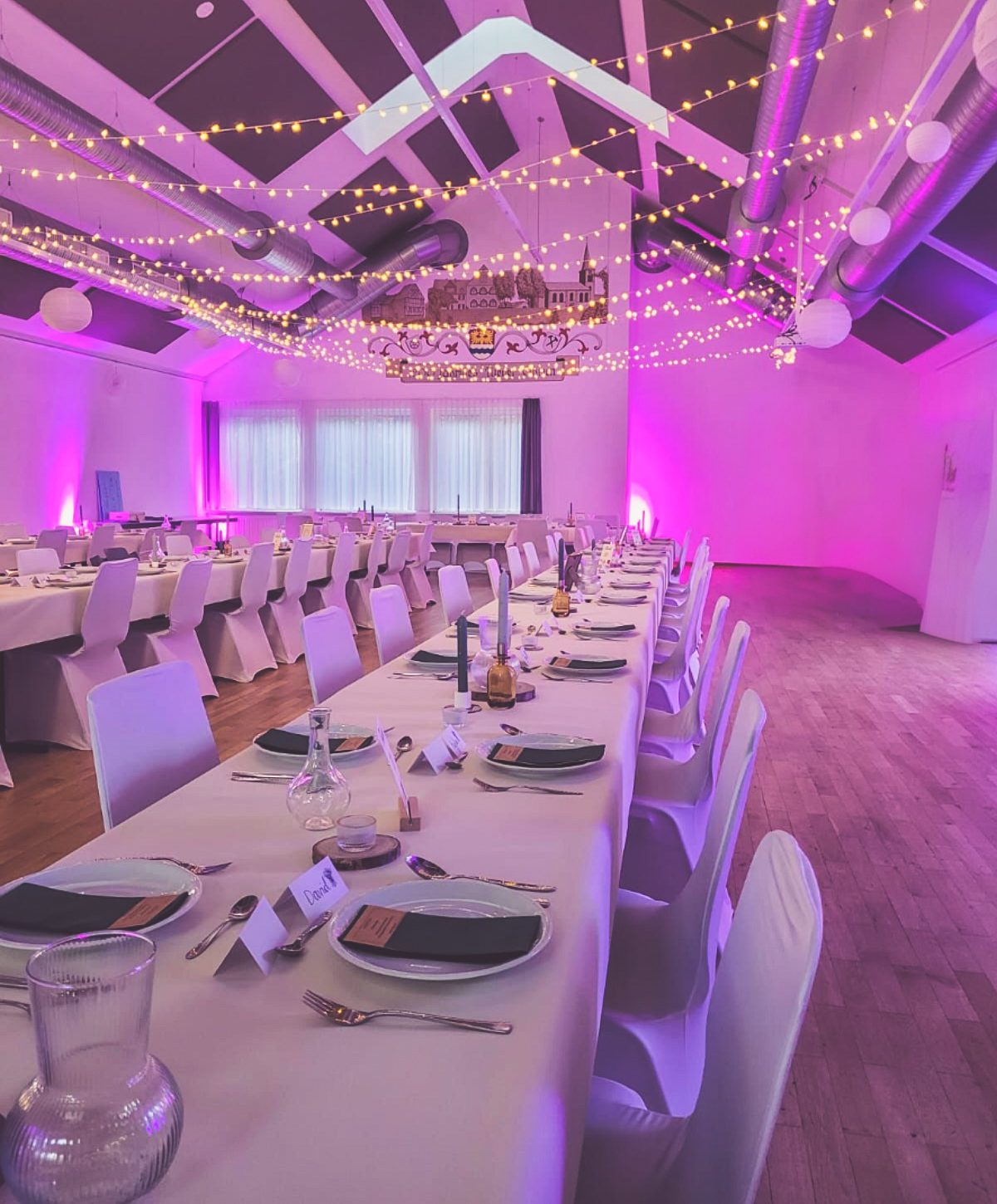 Stuhlhussen Dorfgemeinschaftshaus Nieder-Ohmen Mücke Weiße Stuhlhussen im Dorfgemeinschaftshaus Nieder-Ohmen in Mücke bei einer Feier – elegante Dekoration für Hochzeiten und besondere Veranstaltungen