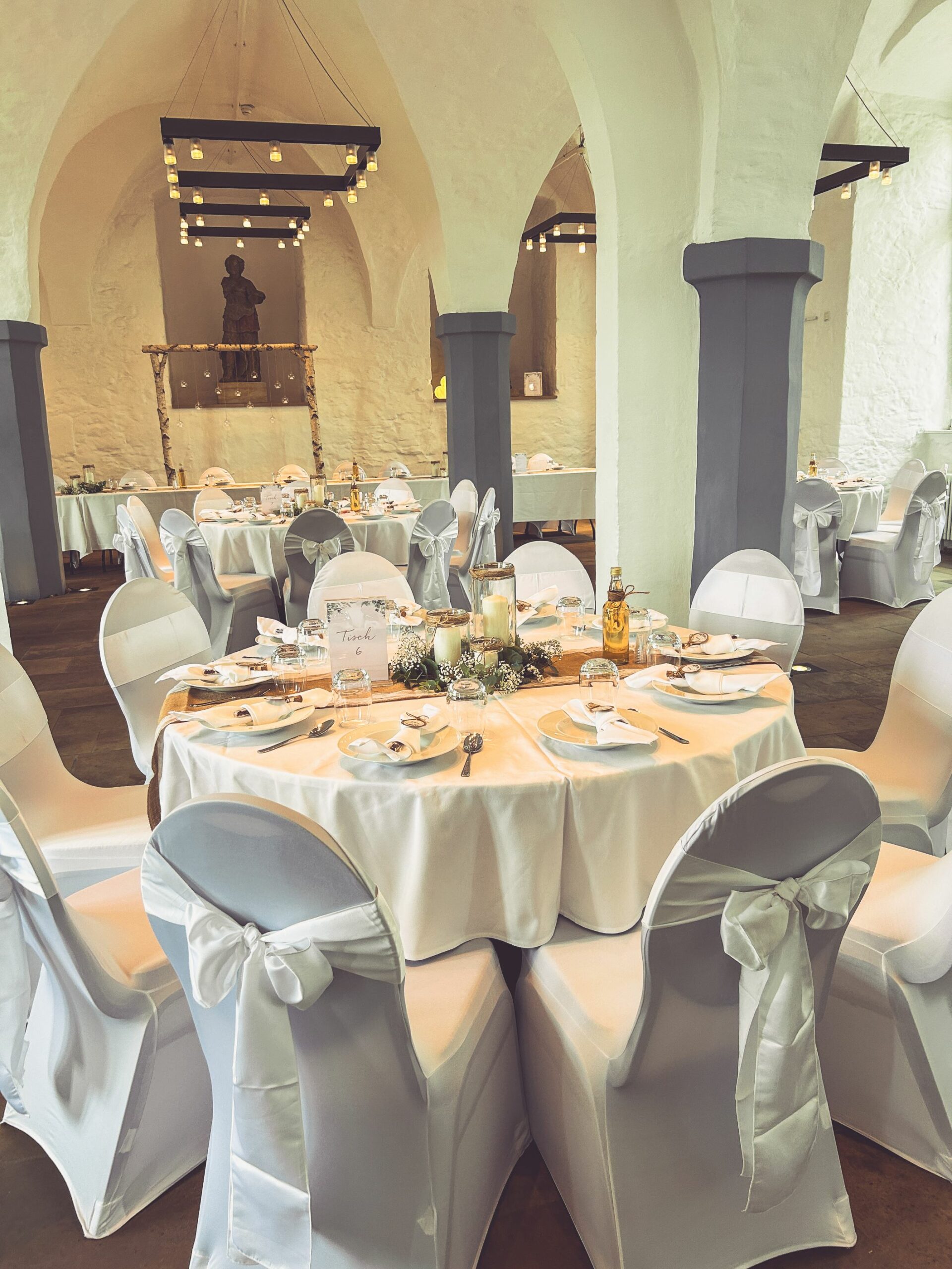 Weiße Stuhlhussen im Gewölbesaal in Butzbach bei einer Feier – elegante Dekoration für Hochzeiten und besondere Veranstaltungen