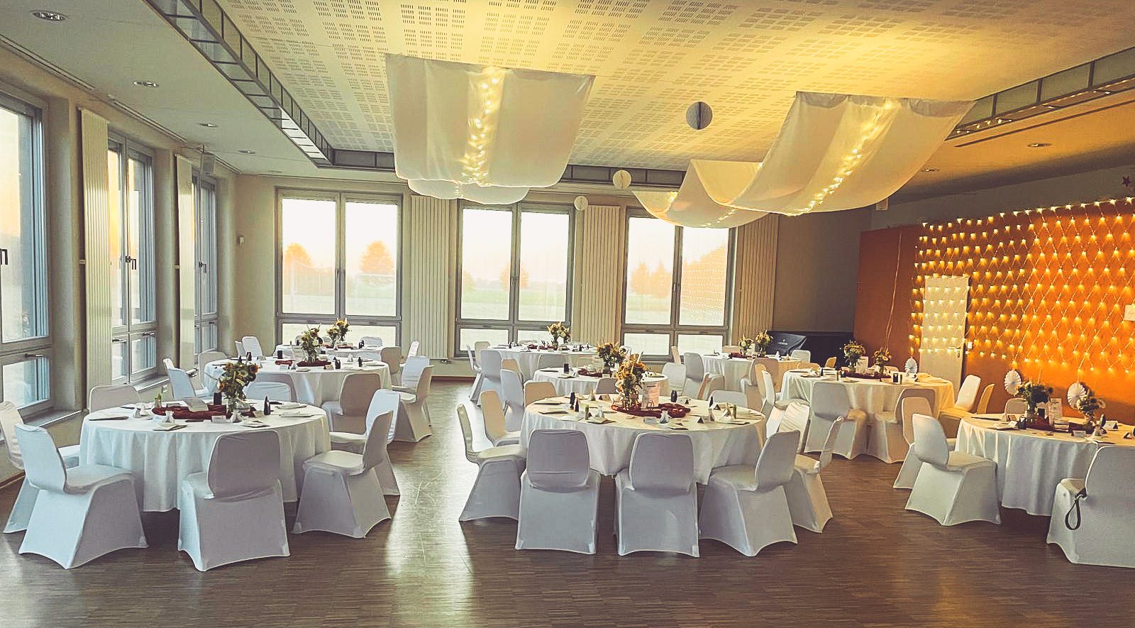 Weiße Stuhlhussen im Gemeindehaus in Hinrichshagen bei einer Feier – elegante Dekoration für Hochzeiten und besondere Veranstaltungen