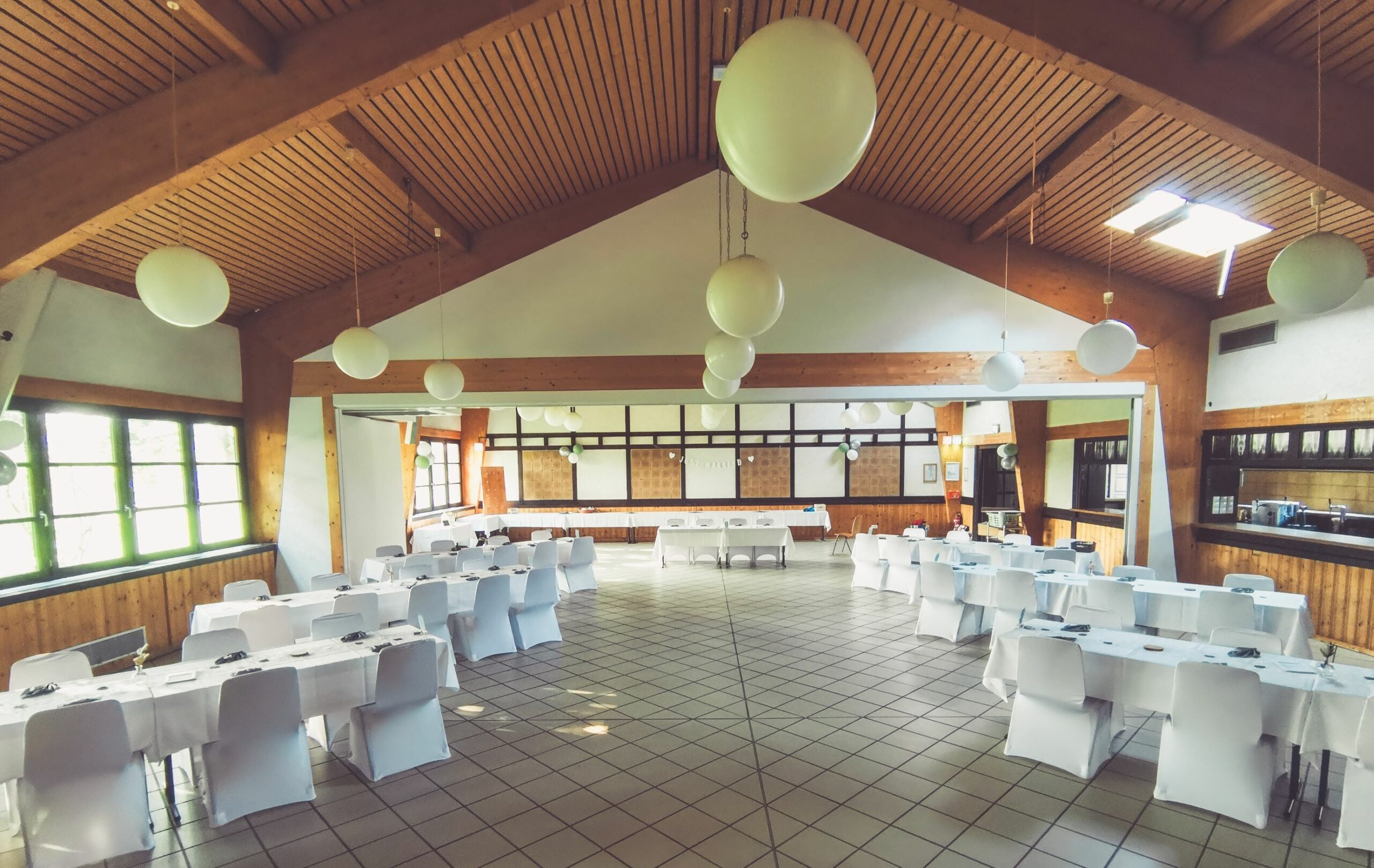 Weiße Stuhlhussen im Dorfgemeinschaftshaus Straßfeld in Swisttal bei einer Feier – elegante Dekoration für Hochzeiten und besondere Veranstaltungen
