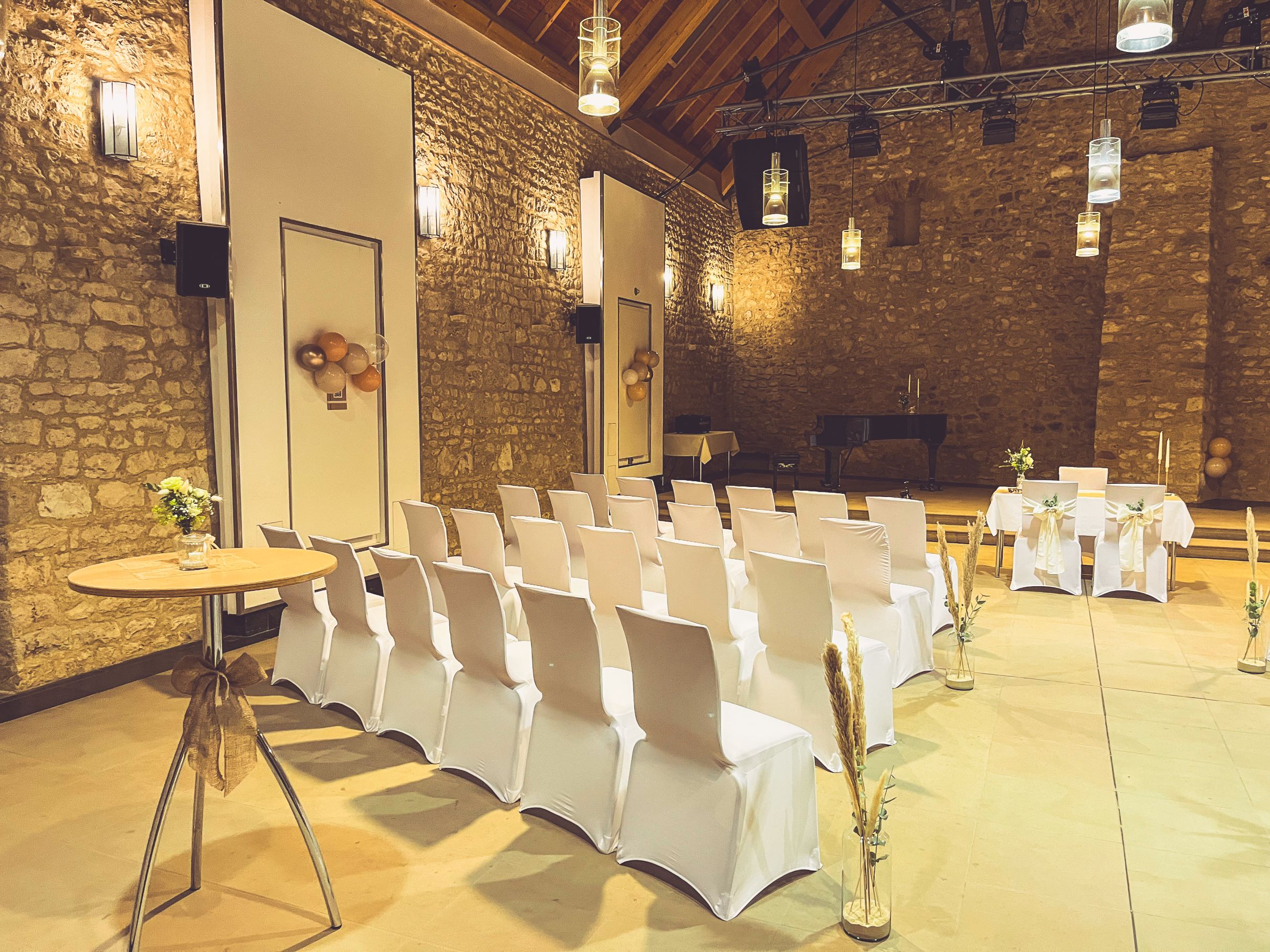 Weiße Stuhlhussen in der Burgscheune in Stadecken-Elsheim bei einer Feier – elegante Dekoration für Hochzeiten und besondere Veranstaltungen