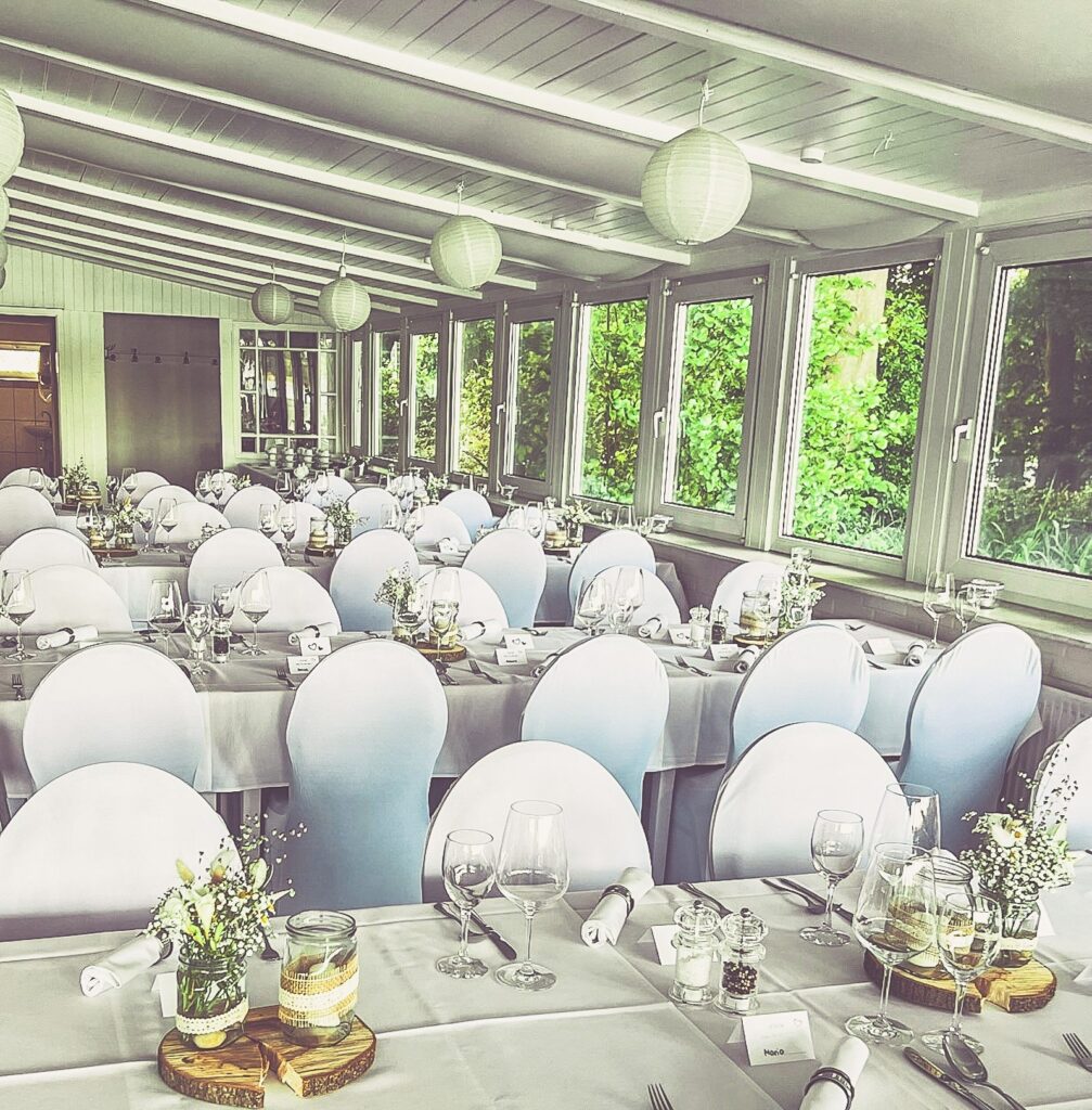 Weiße Stuhlhussen in der Bokel-Mühle am See in Bokel bei einer Feier – elegante Dekoration für Hochzeiten und besondere Veranstaltungen