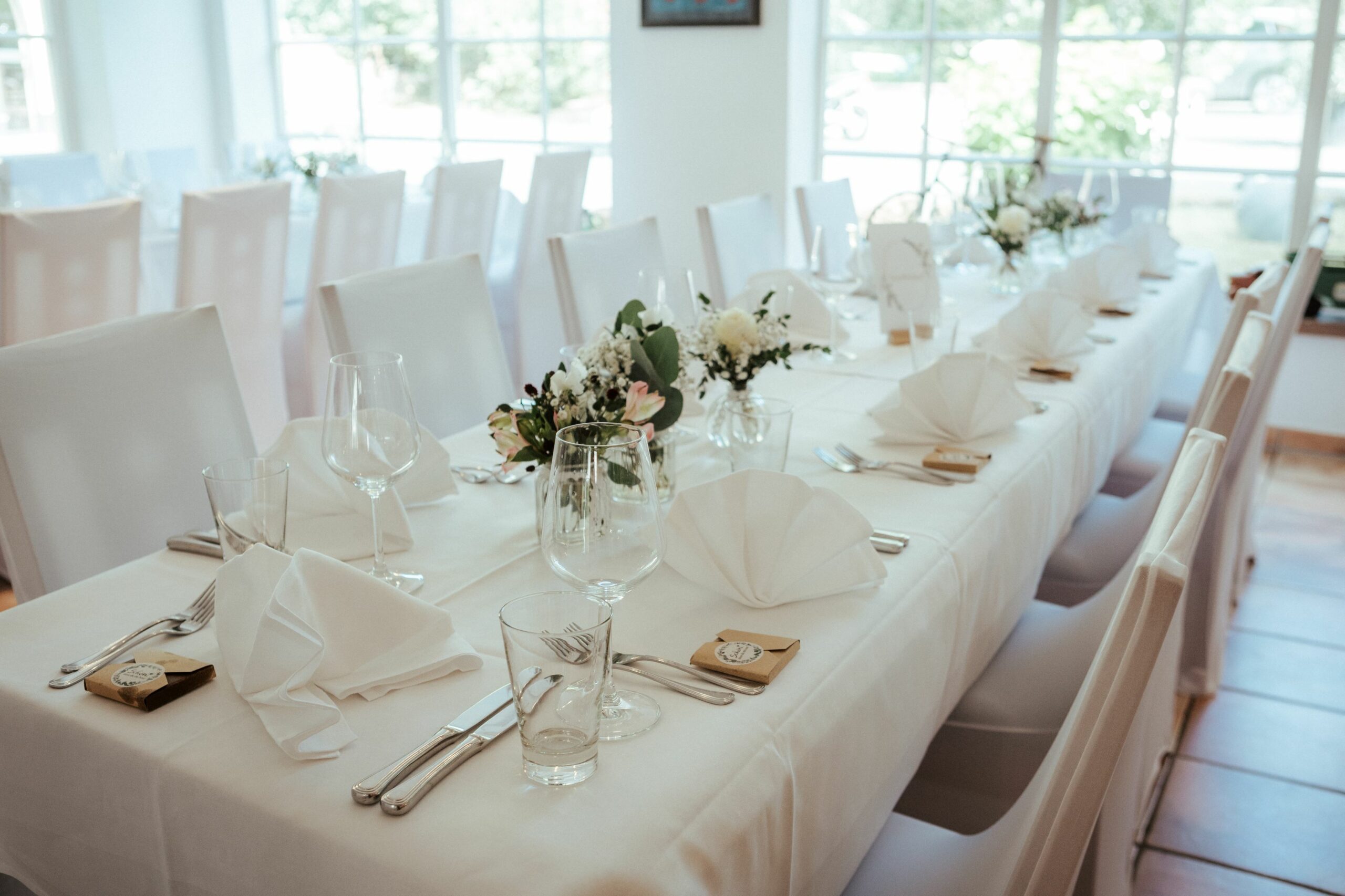 Weiße Stuhlhussen im Hotel Restaurant Dammühle in Marburg bei einer Feier – elegante Dekoration für Hochzeiten und besondere Veranstaltungen