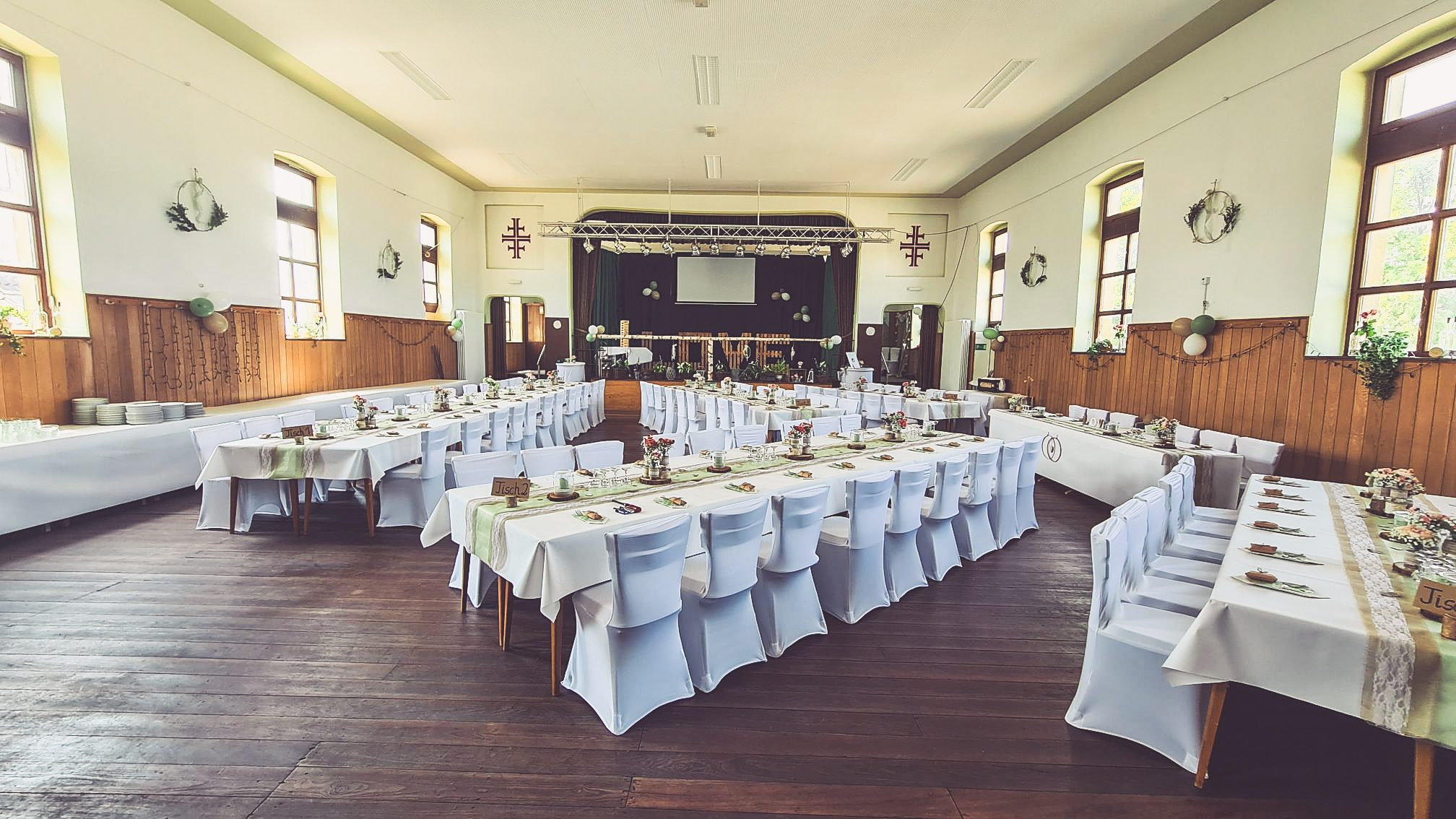 Weiße Stuhlhussen in der Turnhalle in Lettweiler bei einer Feier – elegante Dekoration für Hochzeiten und besondere Veranstaltungen