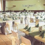 Weiße Stuhlhussen in der Dorfgemeinschaftshalle in Niedersayn bei einer Feier – elegante Dekoration für Hochzeiten und Veranstaltungen