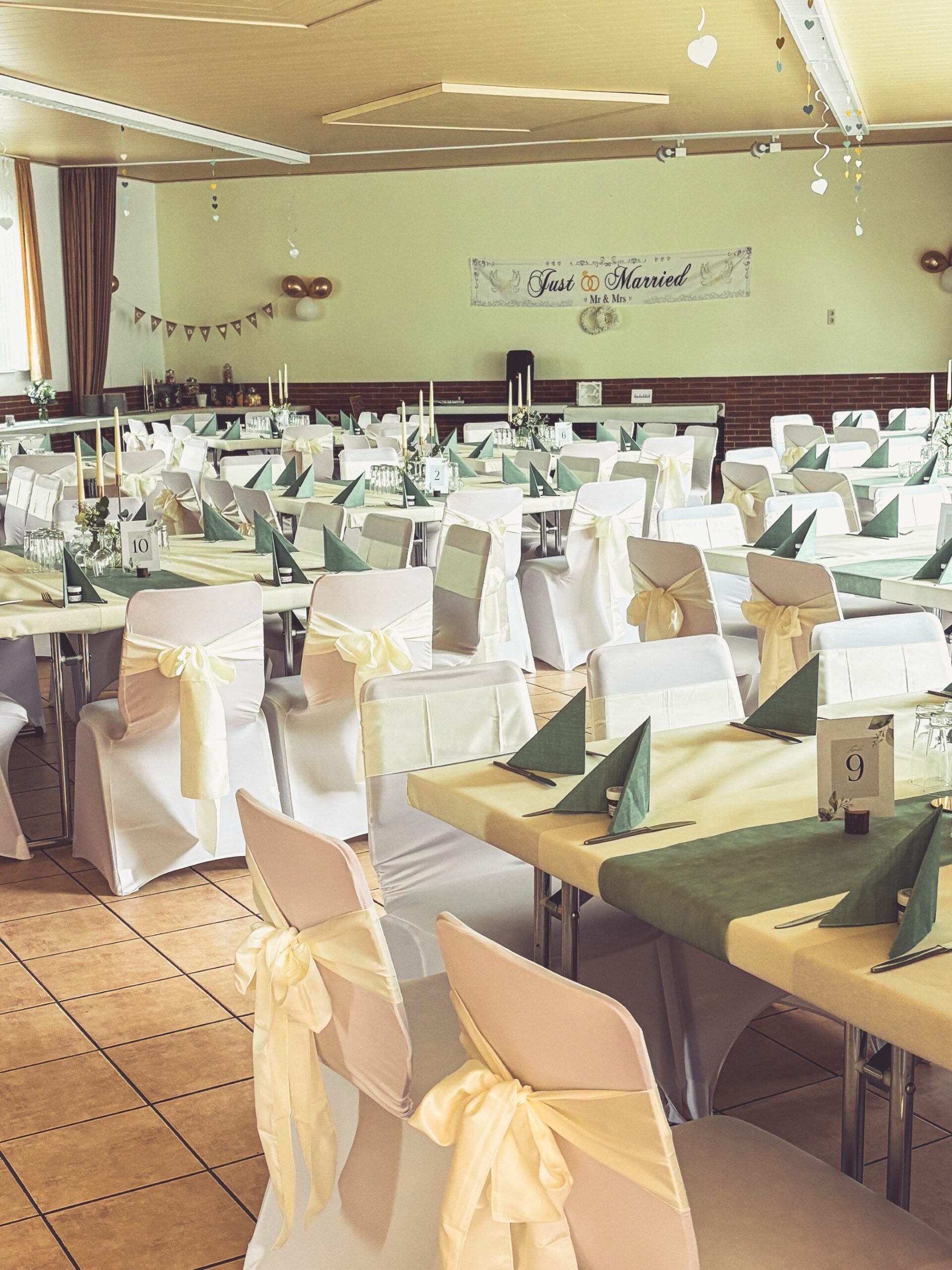Weiße Stuhlhussen in der Dorfgemeinschaftshalle in Niedersayn bei einer Feier – elegante Dekoration für Hochzeiten und Veranstaltungen
