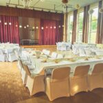 Weiße Stuhlhussen im Gemeinschaftshaus Karlshof e.V. in Lübeck bei einer Feier – elegante Dekoration für Hochzeiten und besondere Veranstaltungen