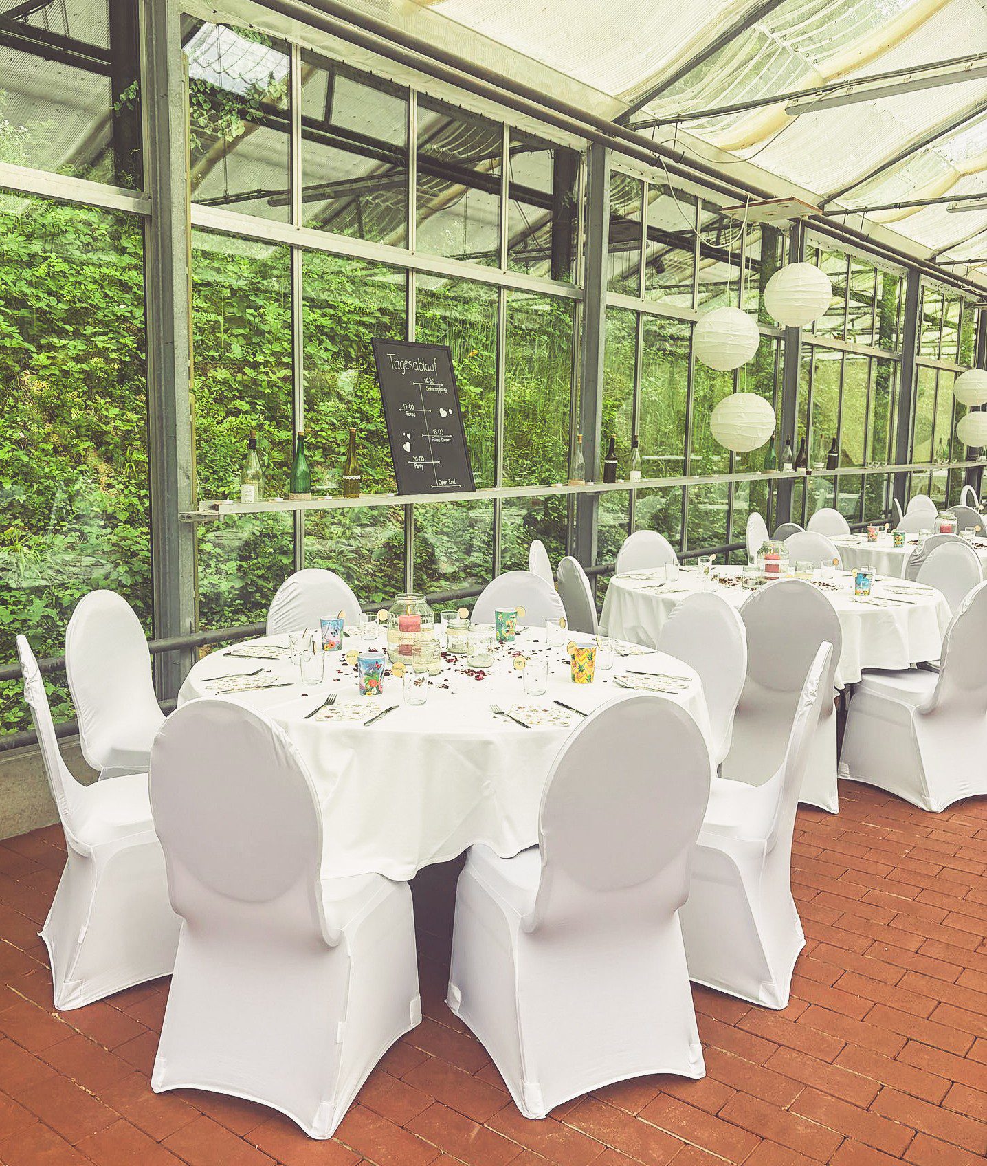 Weiße Stuhlhussen im Staatspark Fürstenlager Glashaus in Bensheim bei einer Feier – elegante Dekoration für Hochzeiten und besondere Veranstaltungen