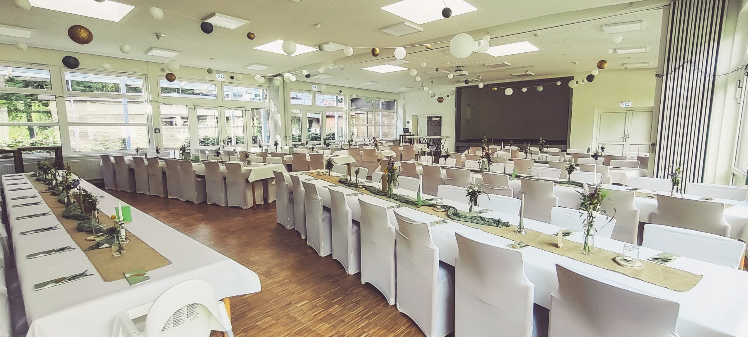 Weiße Stuhlhussen im Dorfgemeinschaftshaus in Soderstorf bei einer Feier – elegante Dekoration für Hochzeiten und besondere Veranstaltungen