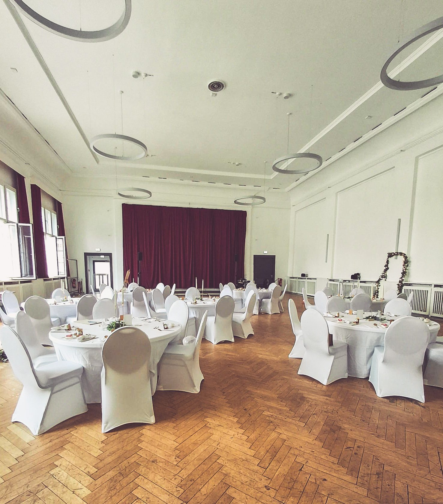 Stuhlhussen Volkspark Halle Kleiner Saal Weiße Stuhlhussen im Volkspark in Halle im Kleinen Saal bei einer Feier – elegante Dekoration für Hochzeiten und Veranstaltungen
