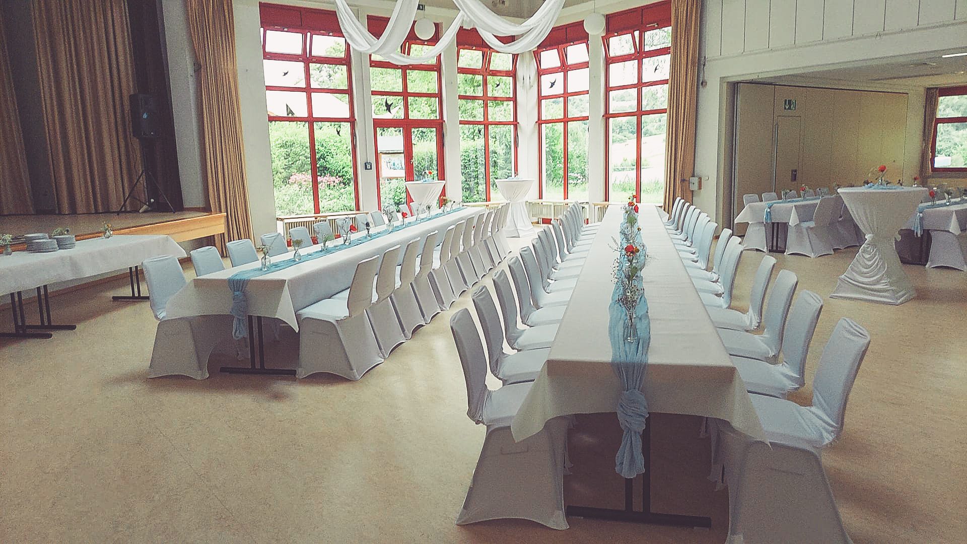 Weiße Stuhlhussen im Dorfgemeinschaftshaus Eckartshausen in Büdingen bei einer Feier – elegante Dekoration für Hochzeiten und Veranstaltungen