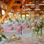Weiße Stuhlhussen in der Rhönlandscheune in Dermbach bei einer Feier – elegante Dekoration für Hochzeiten und Veranstaltungen
