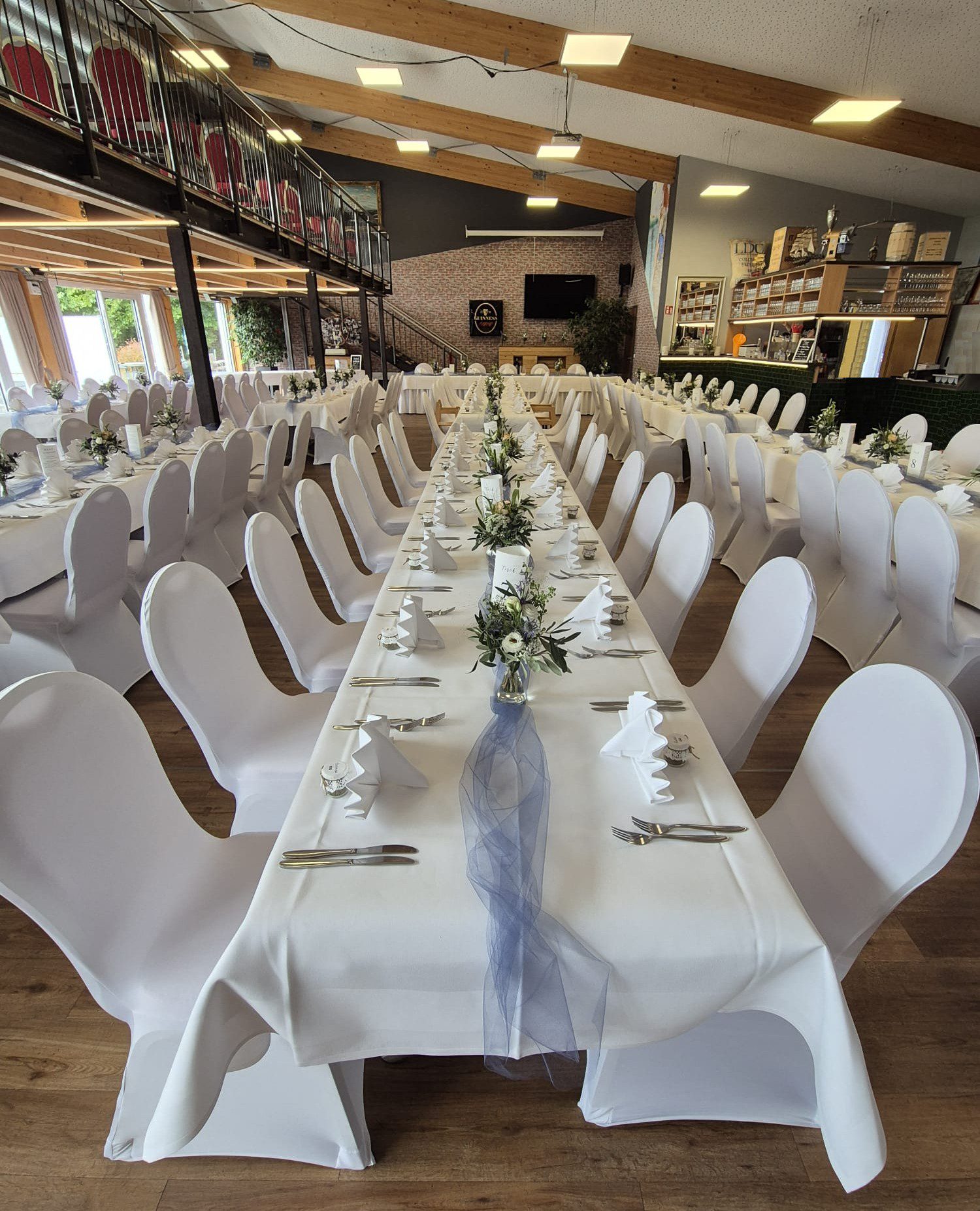 Weiße Stuhlhussen in der Hafenhalle in Breisach am Rhein bei einer Feier – elegante Dekoration für Hochzeiten und Veranstaltungen