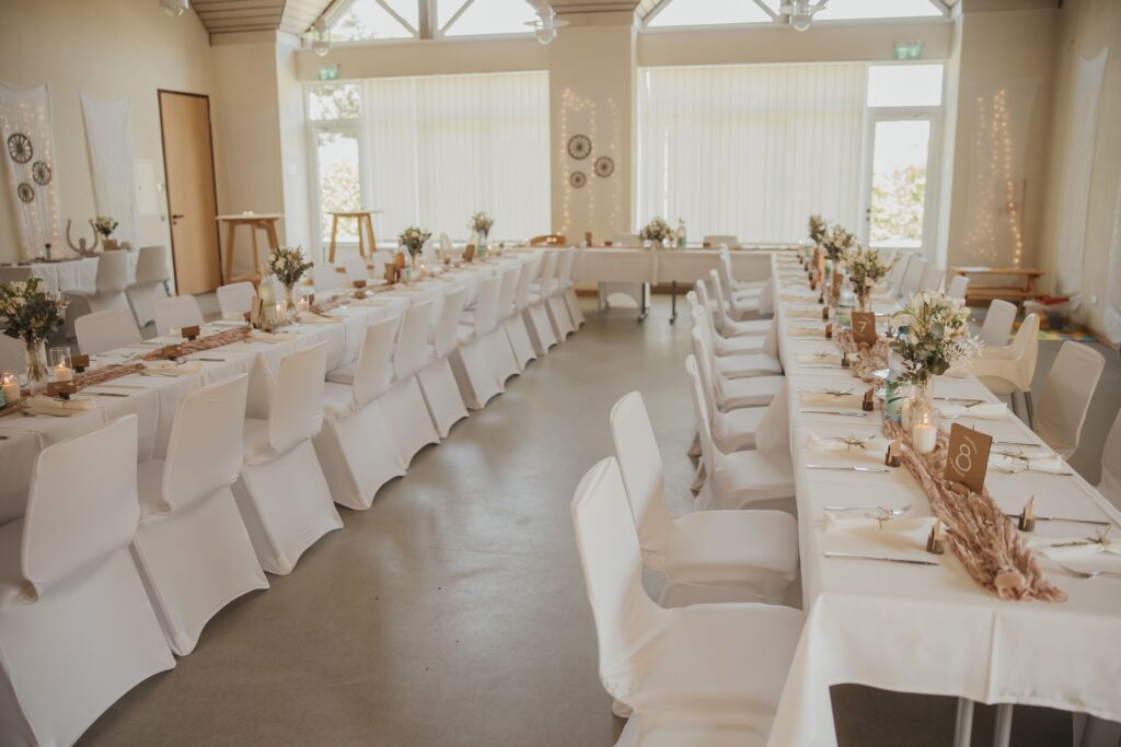 Weiße Stuhlhussen im Dorfgemeinschaftshaus Heuchelheim in Reichelsheim bei einer Feier – elegante Dekoration für Hochzeiten und Veranstaltungen