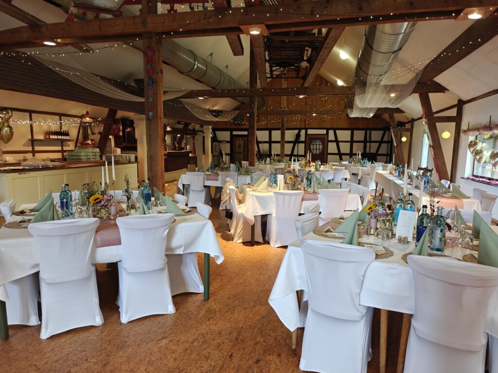 Weiße Stuhlhussen im Nikolausehof in Heppenheim bei einer Feier – elegante Dekoration für Hochzeiten und besondere Veranstaltungen