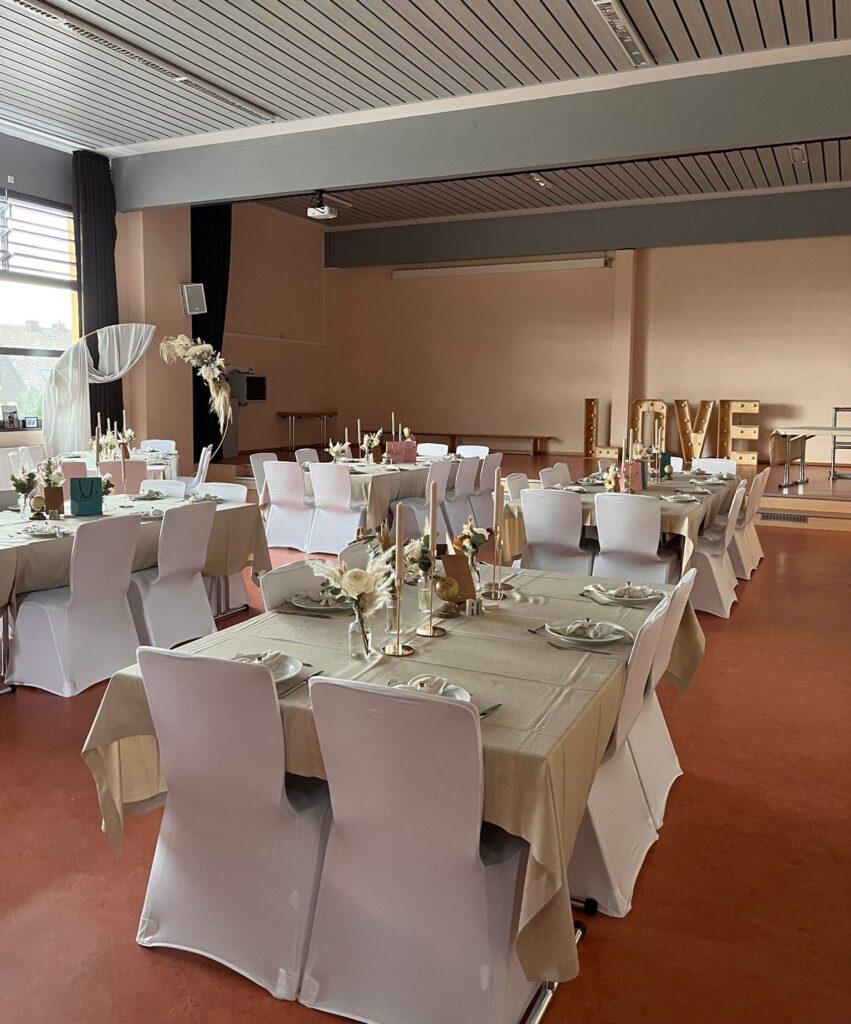 Weiße Stuhlhussen bei einer Feier mit 95 Personen im Bürgerhaus Frankenbach in Biebertal