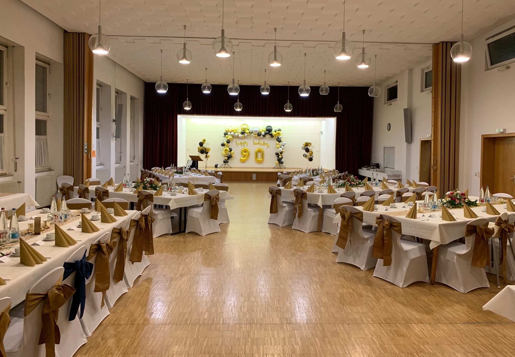 Stuhlhussen mit goldenen Schleifen im Luther-Gemeindehaus Bad Cannstatt Weiße Stuhlhussen mit goldenen Schleifen beim 90. Geburtstag im Luther-Gemeindehaus Bad Cannstatt