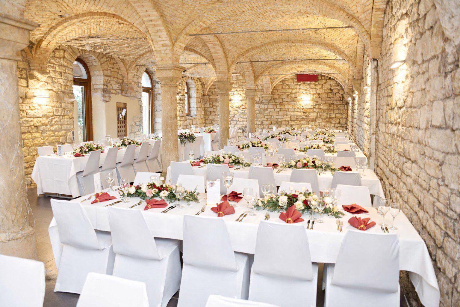 Weiße Stuhlhussen bei einer Hochzeit mit 80 Personen im Kreuzgewölbe des Alten Weinguts am Maxbrunnen in Bad Dürkheim