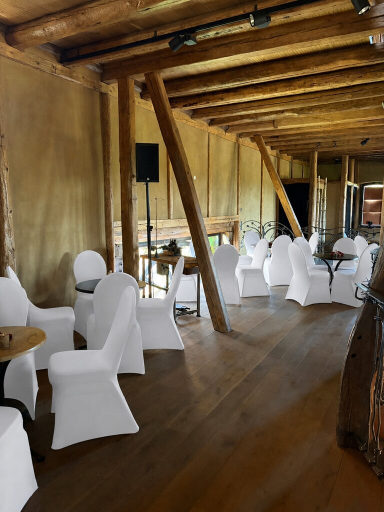 Weiße Stuhlhussen bei einer Hochzeit mit 120 Personen in der Kultur- und Event-Scheune in Reichelsheim