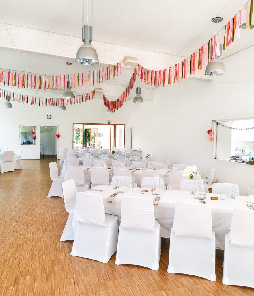 Weiße Stretch-Stuhlhussen bei einer Hochzeit im Dorfgemeinschaftshaus Liebenscheid mit 135 Personen.
