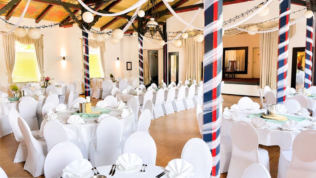 Weiße Stretch-Stuhlhussen im Festsaal des Hotel Ovelgönner Hof in Buxtehude bei einer Hochzeit mit 110 Personen.