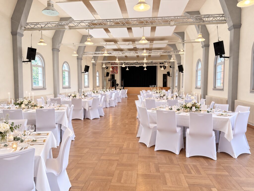 Hochzeit in der Festhalle Dudenhofen mit weißen Stuhlhussen und Tischdecken
