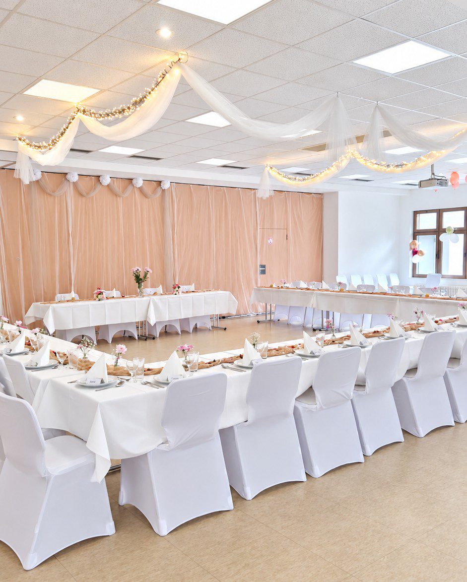 Hochzeit in der Hausberghalle Butzbach mit weißen Stuhlhussen und Tischdecke