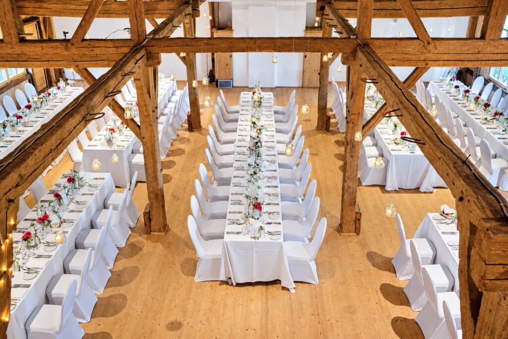 Hochzeit im Gut Waltersteig Eurasburg mit weißen Stuhlhussen und langen Tafeln