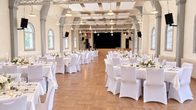 Weiße Stuhlhussen und festlich gedeckte Tafeln in der Festhalle Dudenhofen Hochzeit in der Festhalle Dudenhofen mit weißen Stuhlhussen und Tischdecken